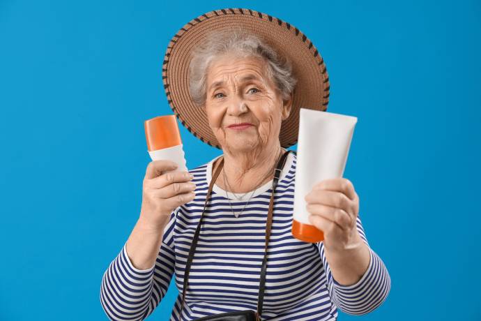 Senior woman with sunscreen cream