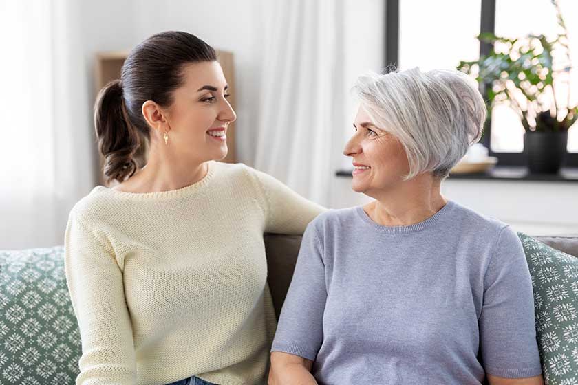 Senior mother with adult daughter talking at home